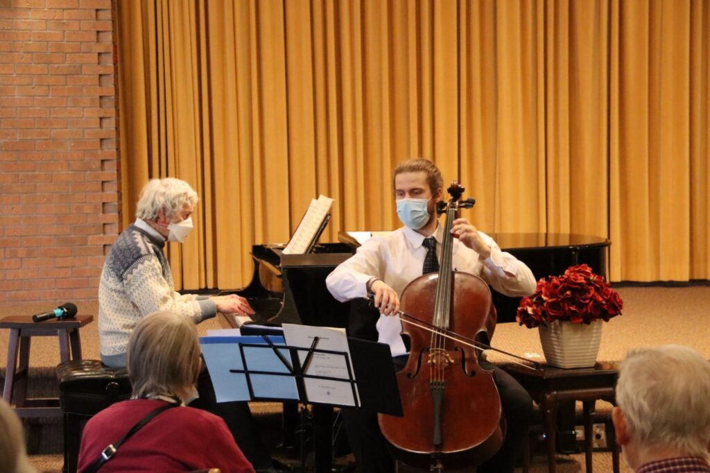 Man performing with cello at retirement living centre